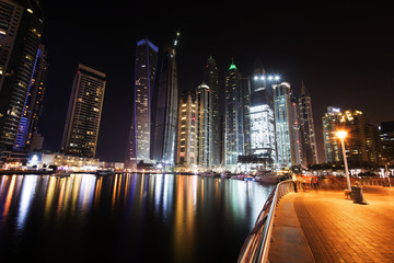 Obraz premium Architecture theme. Dubai marina. Luxurious travel and living, business and finance theme. Luxurious apartments. High value property. Night lights. Illuminated skyline. Big construction site.