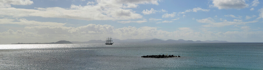 Ocean Panorama Square Rigged Tall Ship with the Northern Coast of Fuerteventura and the Island of Lobos in the Background.