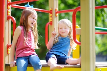 Fototapeta na wymiar Two cute little girls having fun on a playground