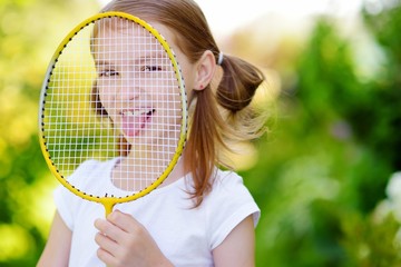 Cute little girl playing badminton outdoors