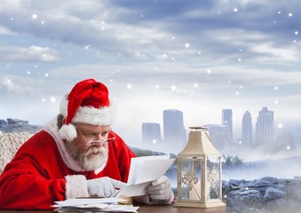 Santa sitting at table and reading christmas letter
