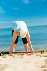 Senior woman warming up with walking poles