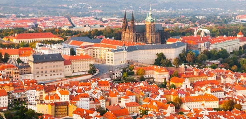 Papier Peint photo Prague Prague Castle complex with gothic St Vitus Cathedral in the evening time illuminated by sunset, Hradcany, Prague, Czech Republic. UNESCO World Heritage. Panoramic aerial shot from Petrin Tower.