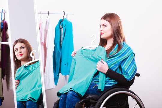 handicapped girl on wheelchair choosing clothes