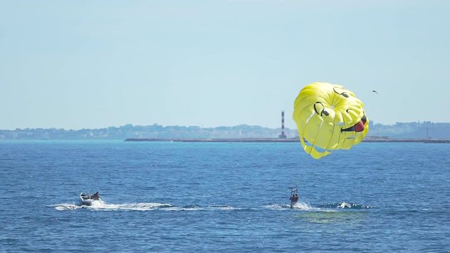 Happy people parasailing above blue sea, parachute sports, summer activities