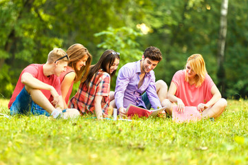 Fototapeta premium group of happy students with books in the Park on a Sunny day