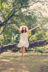 Young teen girl sitting on tree