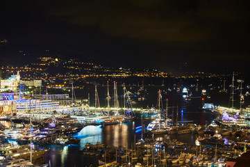 World Fair MYS Monaco Yacht Show at night, Port Hercules, luxury megayachts, many shuttles, party time, boat traffic, long exposure, aerial view, cityscape, night lights, illumination of boat