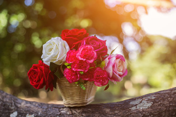 Mixed beautiful flowers in the vase on wooden background