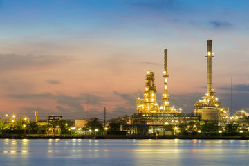 Obraz na płótnie Canvas Oil refinery light river front with twilight sky background