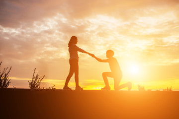 Fototapeta premium a silhouette of a man and woman holding hands with each other, w