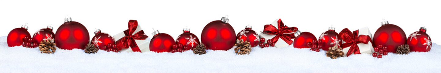 row of red christmas baubles balls in snow isolated on white background
