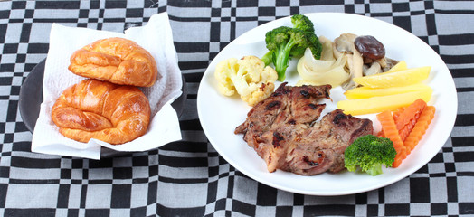 Home made ,Pork steak and mixed vegetables with croissants .