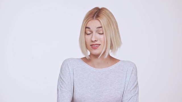 Young beautiful disagreed and critical blonde girl over white background