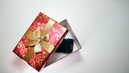 Smartphone In Red Gift Box On White Background