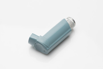 Asthma inhaler with spacer on white background