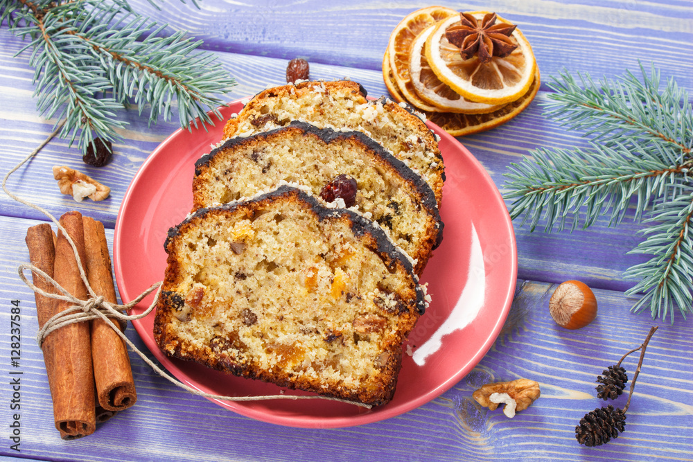 Wall mural fresh baked fruitcake for christmas on plate and spruce branches on boards