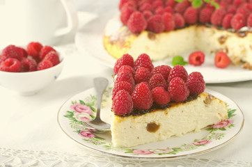 Cheesecake, souffle, cream mousse, pudding dessert with fresh raspberries and mint leaves on a white plate