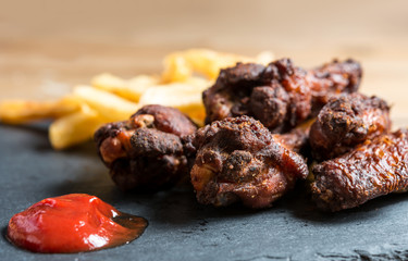 Chicken wings with sauce and golden French fries potatoes