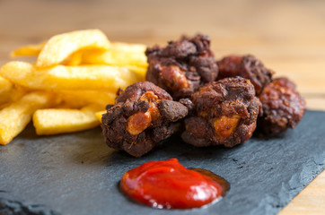 Chicken wings with sauce and golden French fries potatoes