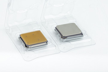 Two CPU in the open box. The first processor is upside. The second processor is turned bottom up. Isolated on white background.