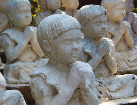 statues of children in prayer position