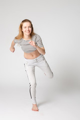 barefoot attractive runner girl starting her run, standing on one leg, studio shot