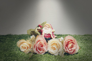 Christmas decoration of Santa Claus with flowers on green grass