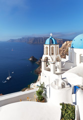 Greece. Santorini Island. Oia village. The bell tower of the Orthodox Church with the traditional blue dome against the backdrop of the Aegean Sea