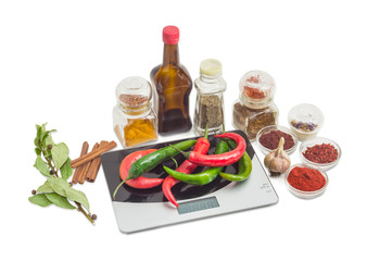 Chili on kitchen scale and various spices, herbs and sauce