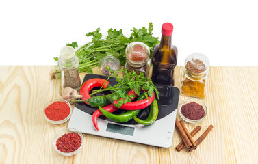 Chili on kitchen scale and various spices, herbs and sauce