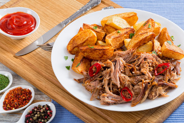 pork shoulder grilled in oven with fried potato wedges