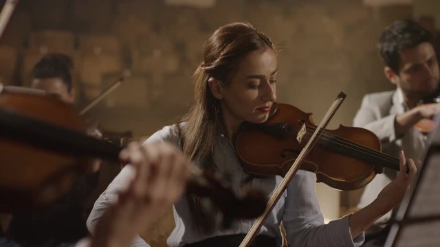 Close-up of musician playing violin on the symphony hall. Shot on RED EPIC Cinema Camera in slow motion.
