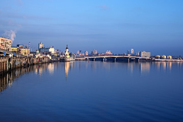 KYIV, UKRAINE – 16 November 2016: Morning city landscape. The embankment near the river port. Church of St. Nicholas the Wonderworker in the waters and Harbor bridge