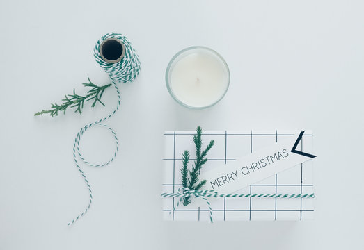 Gitf box with text Merry Christmas card and glass of white  candle