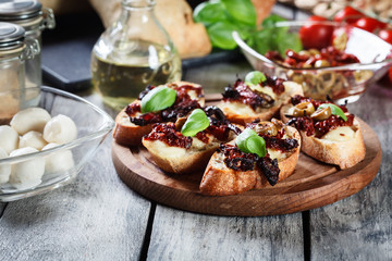 Appetizer bruschetta with sun-dried tomatoes, olives and mozarella.
