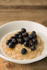 Breakfast Porridge, Blueberry Topped Oatmeal on Wooden Backgroun