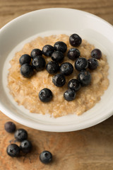 Breakfast Porridge, Blueberry Topped Oatmeal on Wooden Backgroun