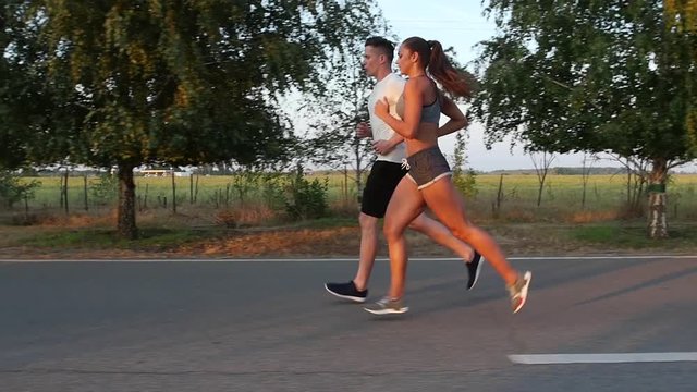 Young couple having fun for a morning jog. Slow motion
