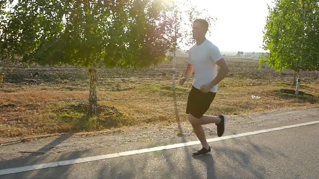 Morning young man running. Marathon. Summer. Slow motion