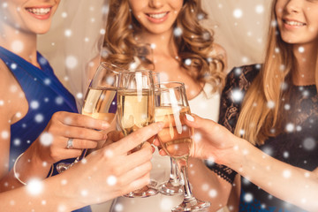 Cheers! Happy girlfriends having new year party and drinking sha