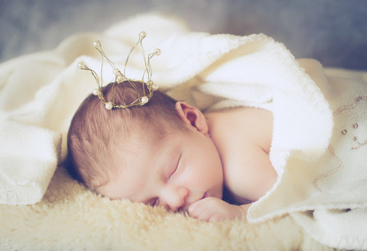 adorable baby princess with golden crown, newborn photography, soft focus