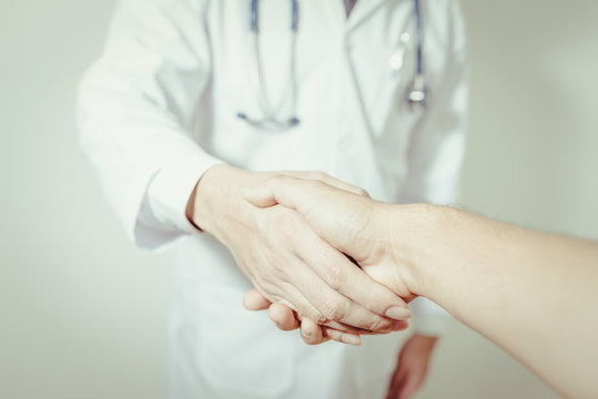 doctor shaking a patient's hands on white background , vintage