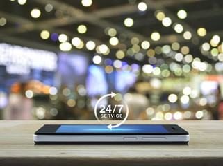 24 hours service icon on modern smart phone screen on table