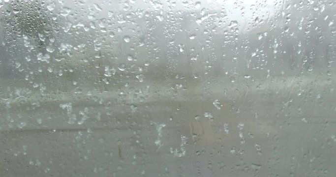 Footage of some rain drops on a window.
