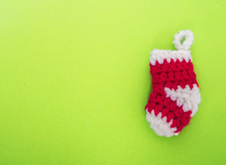 Empty red knitting Christmas sock on green background , copy space