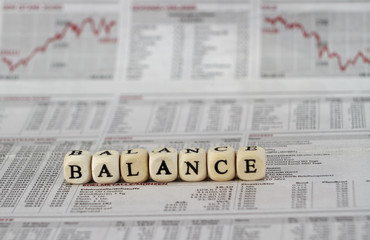 Balance word built with letter cubes on newspaper background
