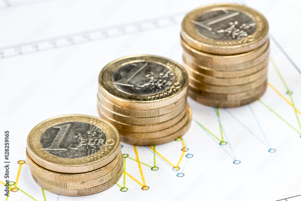 Sticker euro coins on printed financial diagram.