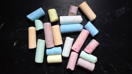 Colored chalks aligned on blackboard
