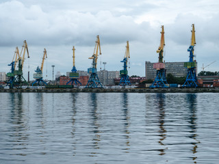 Fototapeta premium Shipping yard, forklifts near the water, crane